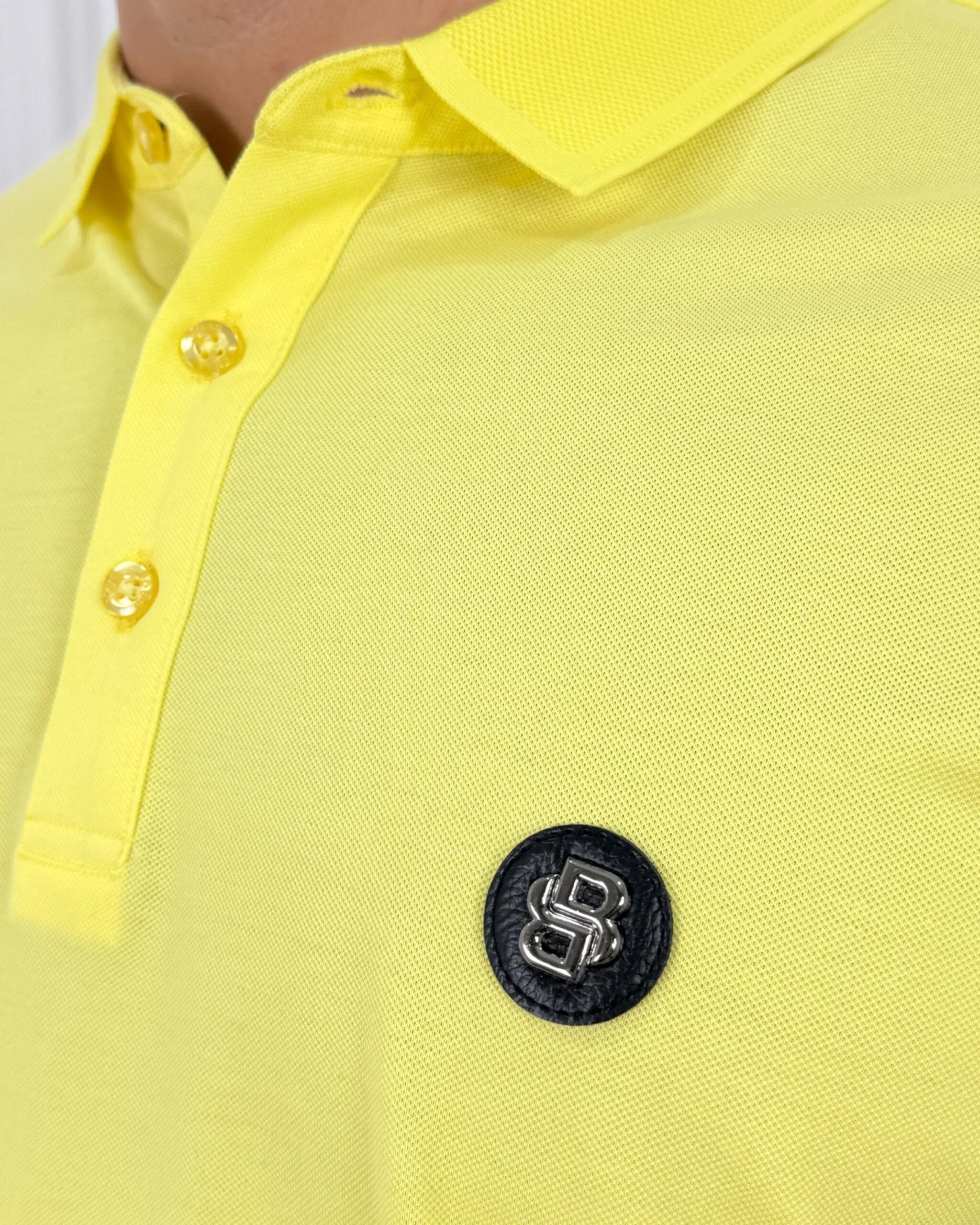 Camisa polo amarilla para hombre, cuello con botones y logo en pecho, tela de calidad premium