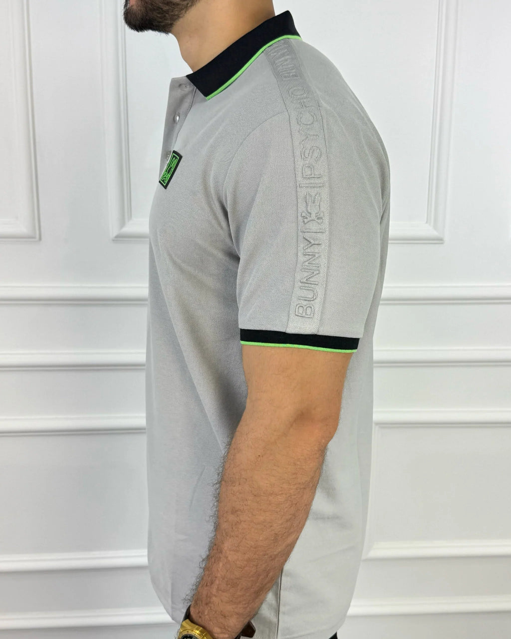 Camisa polo gris con cuello negro y detalles neón, diseño moderno para hombre