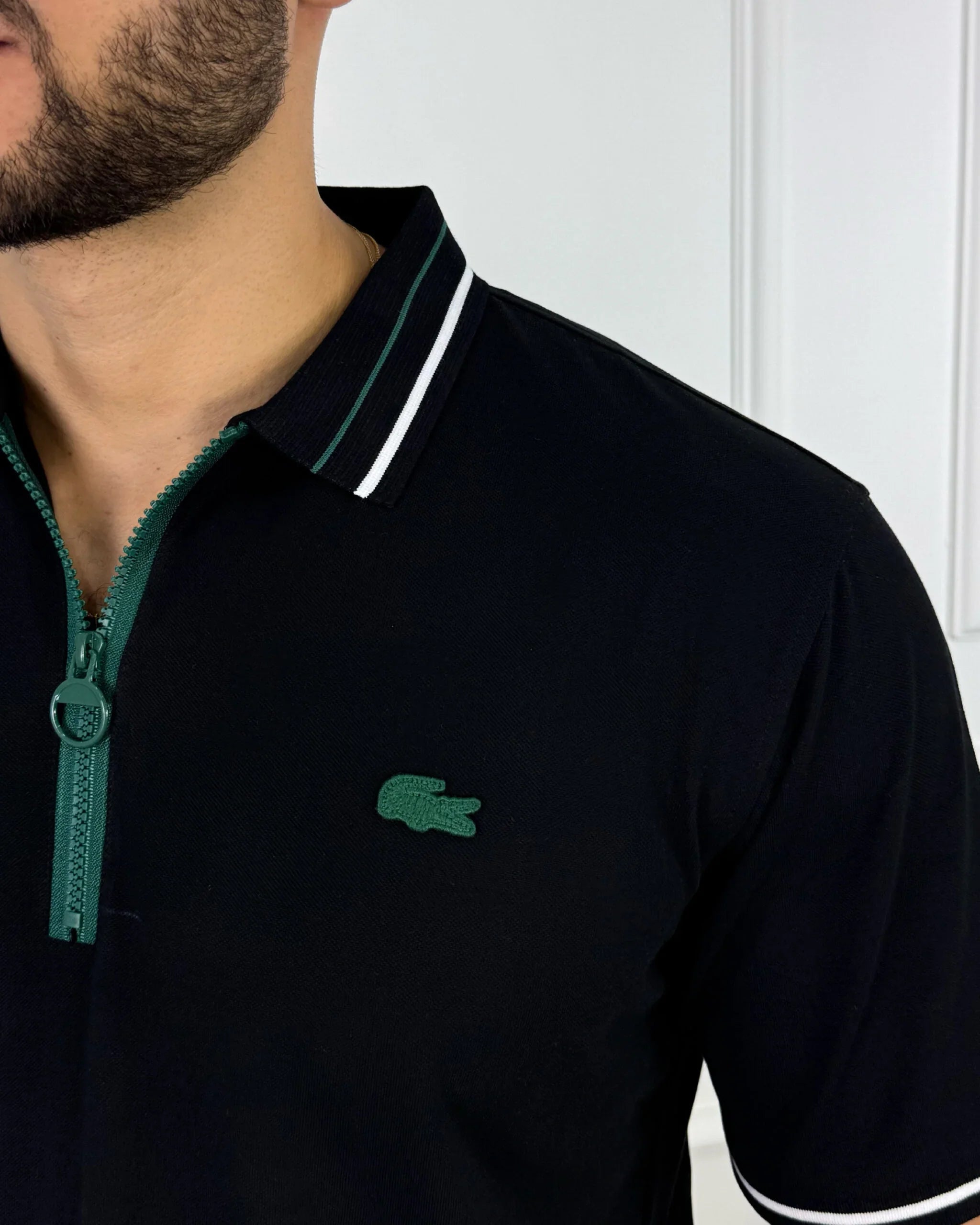 Camisa polo hombre negro con cierre verde y logo bordado, estilo moderno y premium