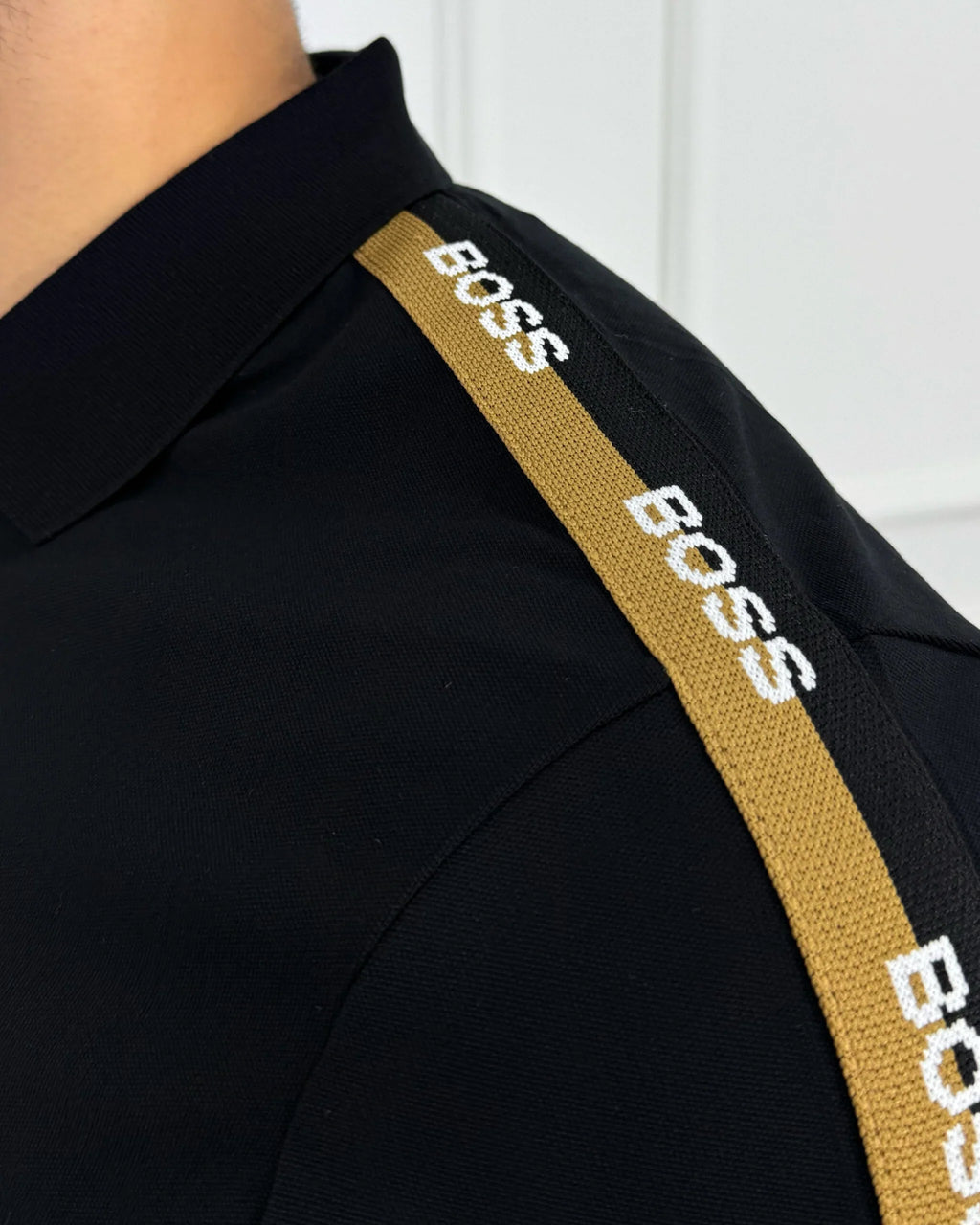Camisa polo negra con detalles BOSS en hombro, estilo moderno y calidad premium para hombre