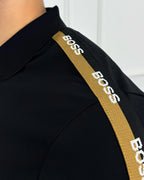 Camisa polo negra con detalles BOSS en hombro, estilo moderno y calidad premium para hombre