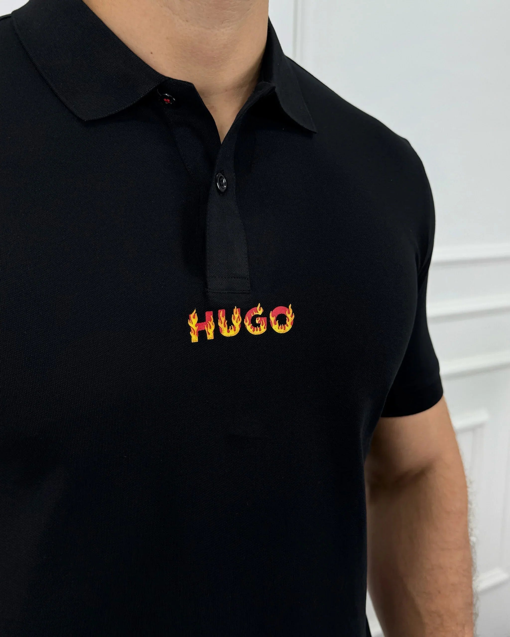 Camisa polo negra para hombre con logo HUGO en llamas, estilo moderno y calidad premium