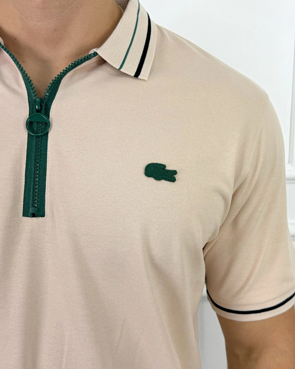 Camisa tipo polo beige con cierre verde y logo bordado, estilo moderno y calidad premium para hombre