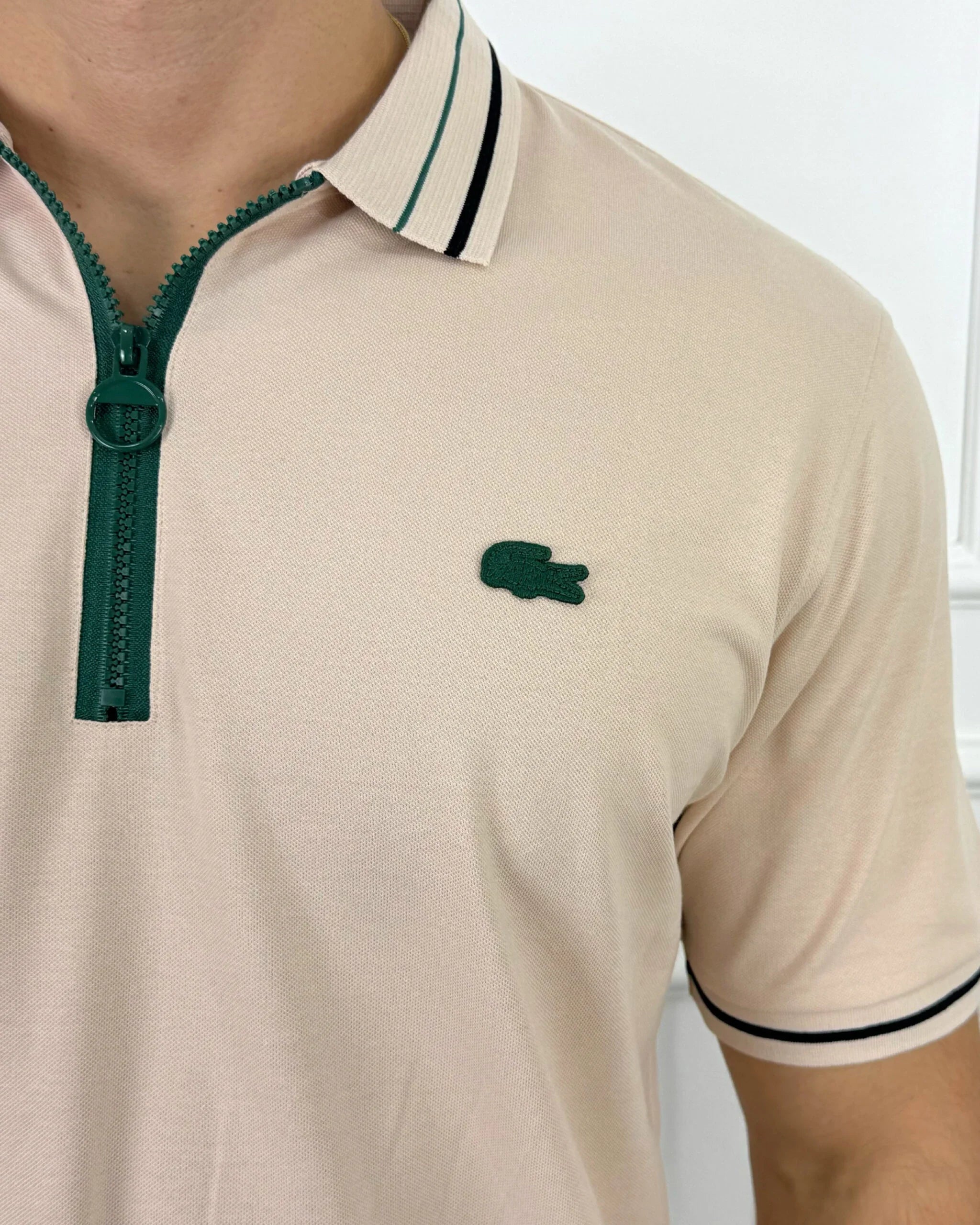 Camisa tipo polo beige con cierre verde y logo bordado, estilo moderno y calidad premium para hombre